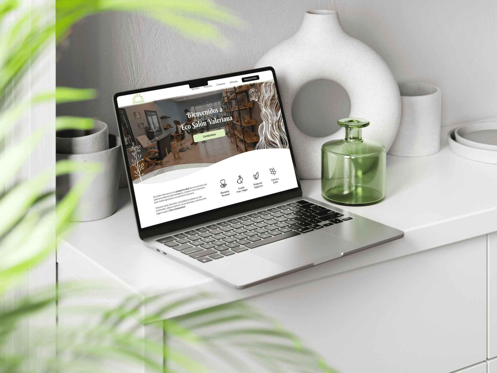 Computador rodeado de plantas mostrando el diseño del sitio web